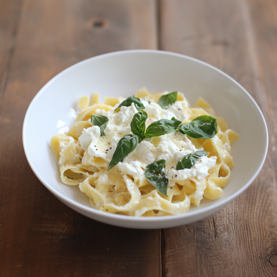 Pasta with ricotta, lemon zest, and roasted cherry tomatoes on a rustic plate.

